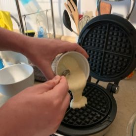 Pouring waffle batter made with sourdough starter discard