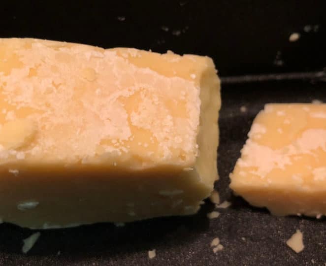 The white crust on this aged cheddar might appear to be mold at first glance, but it's actually calcium lactate crystals, which are safe to eat.