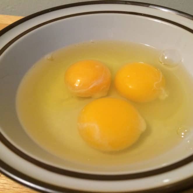 Stringy blobs on yolks are the chalazae and they're safe to eat