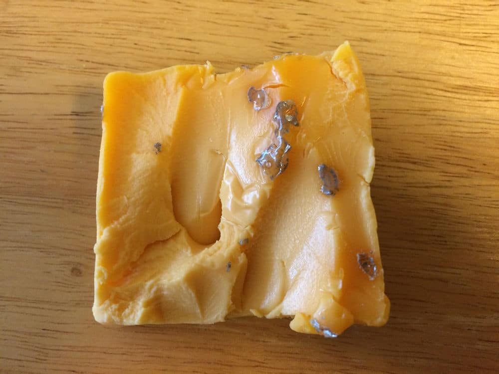 A reaction with aluminum foil left silvery globs on this processed cheese
